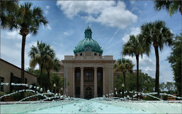 volusia county historic courthouse with water fountain from tck in front of building.
