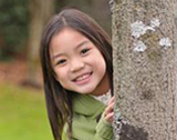 Photo of girl look around a tree