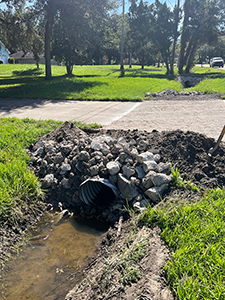 Photo of drainage construction crew replacing deteriorated driveway culvert pipes