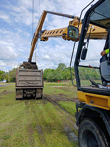 Crews performing maintenance on a retention pond