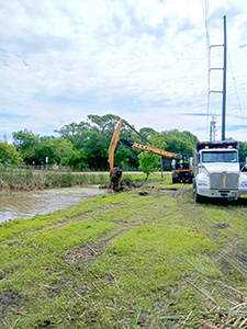 Crews performing maintenance on a retention pond